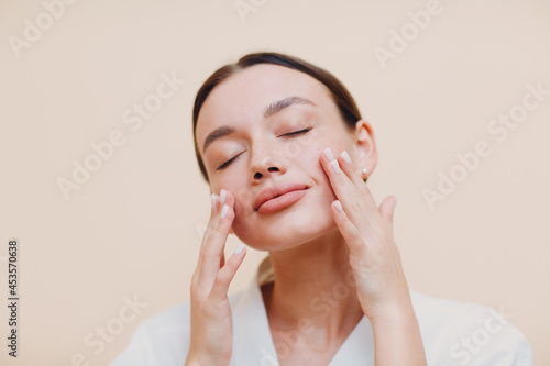 Young caucasian woman doing facebuilding yoga facial gymnastics self lymph facelift massage. photo