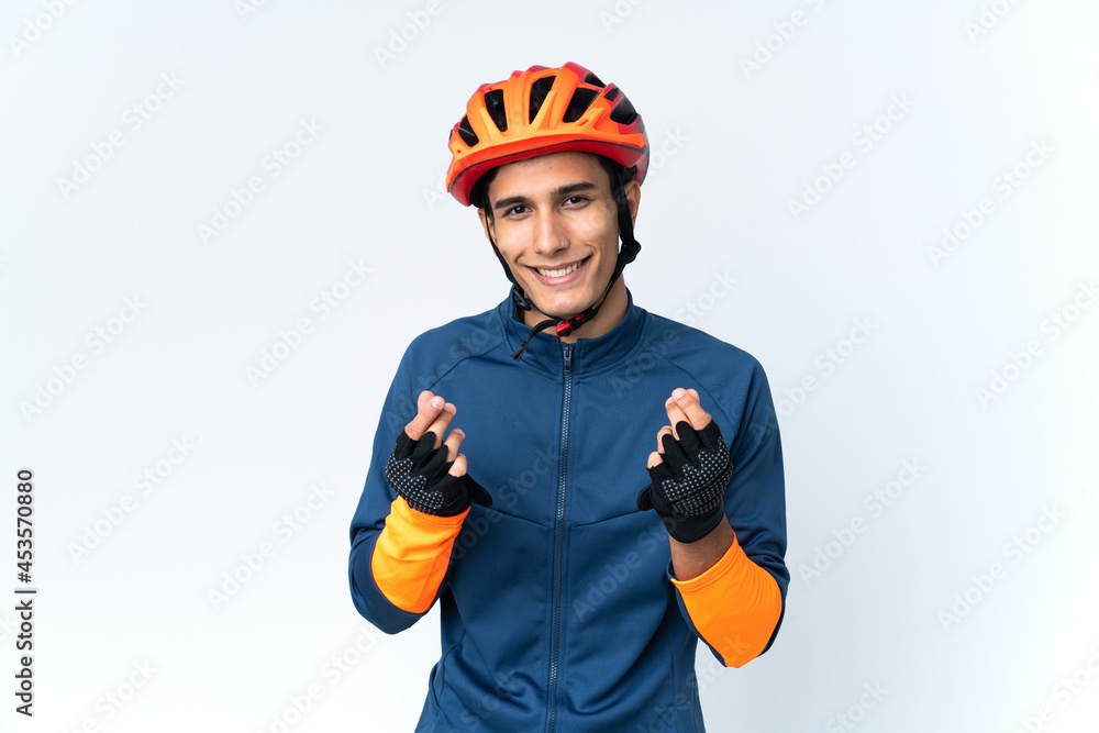 Young cyclist man isolated on background making money gesture Young cyclist man isolated on background making money gesture