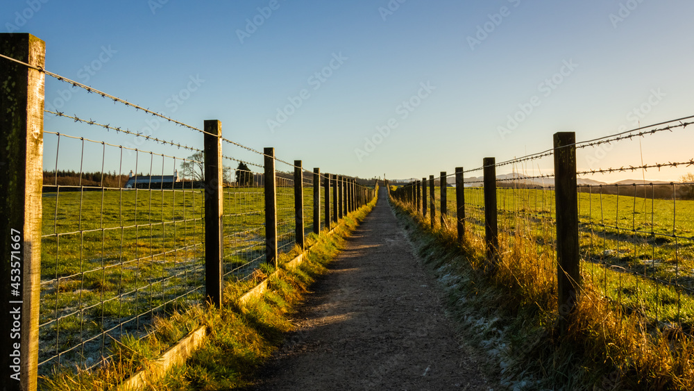 A fenced trail through agricultural land in the Scottish countryside in winter A fenced trail through agricultural land in the Scottish countryside in winter