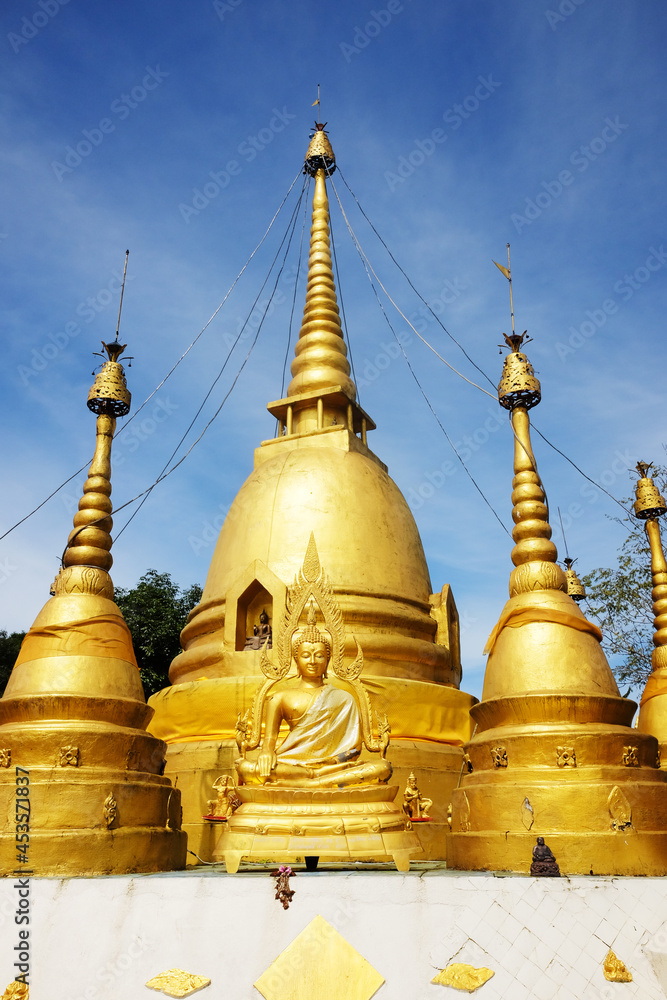 Fototapeta premium Heritage Golden Buddha statue and pagoda located on the mountain of Thai and Myanmar border at Kanchanaburi Province, Thailand