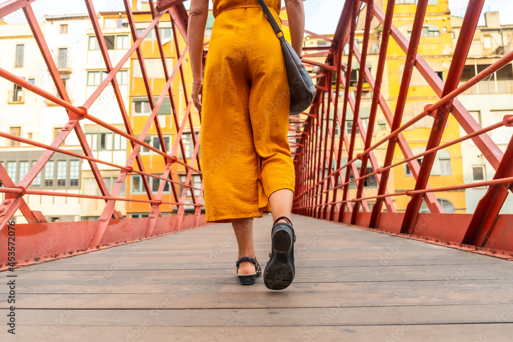 Obraz premium Girona medieval city, a young tourist walking on the famous red bridge Pont de les Peixateries Velles, Costa Brava of Catalonia