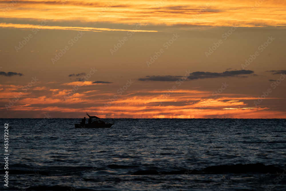 Boat silhouette on the ocean at sunset