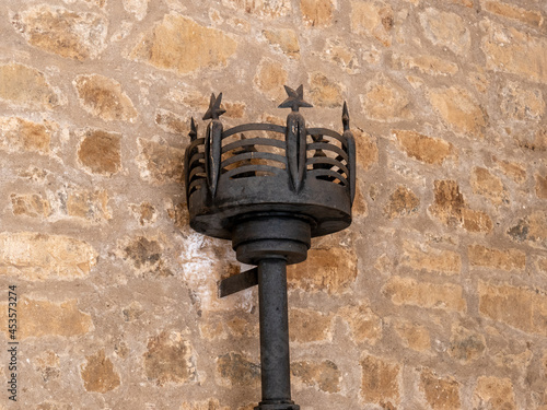 Closeup shot of a black wrought iron cresset torch on a wall