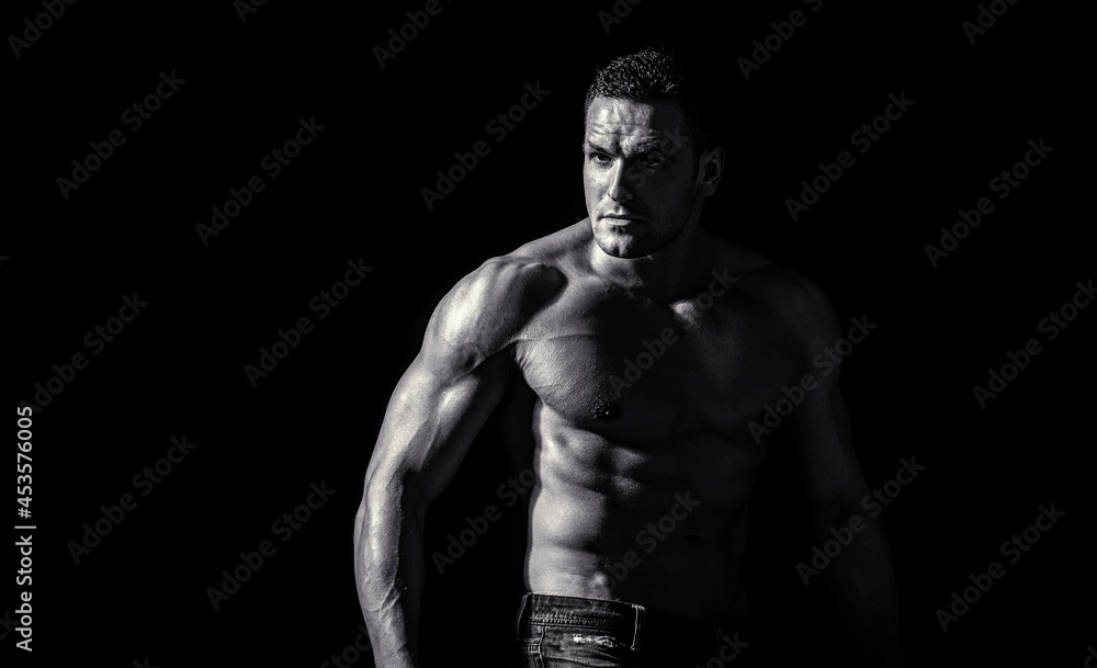 Muscular sexy man with torso. Muscular model sports young man on dark background. Sensual man with naked strong ab. Muscular torso close up. Torso concept. Fashion portrait of strong brutal guy