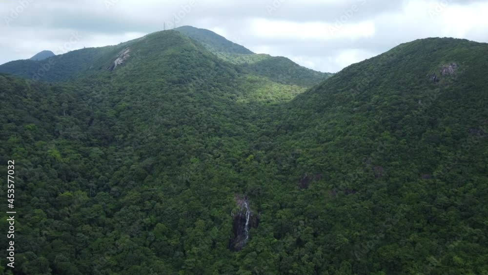 Secret waterfall in the jungles surrounded by mountains on a remote tropical island in Southeast Asia. Aquarium-blue water. Beautiful aerial shot. Drone footage. Vietnam, Con Dao island. Secret waterfall in the jungles surrounded by mountains on a remote tropical island in Southeast Asia. Aquarium-blue water. Beautiful aerial shot. Drone footage. Vietnam, Con Dao island.