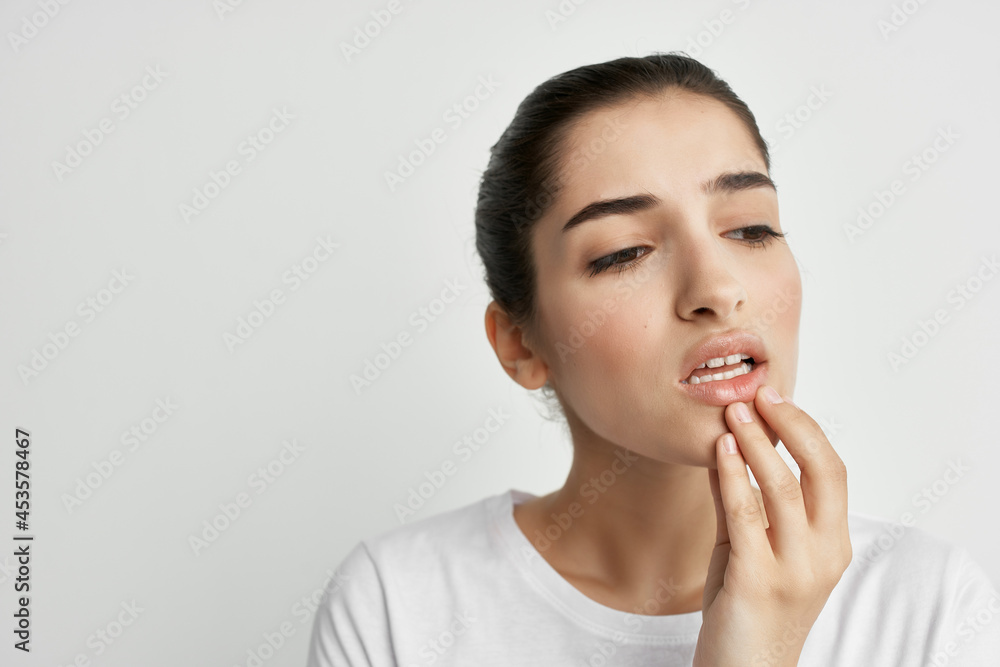 woman in white t-shirt holding face toothache discontent woman in white t-shirt holding face toothache discontent
