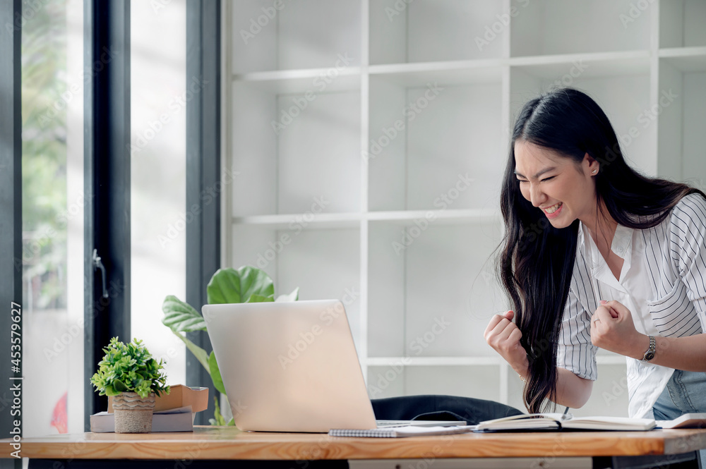 Business Success. Young beautiful asian businesswoman celebrating victory At Work. Copy space. Business Success. Young beautiful asian businesswoman celebrating victory At Work. Copy space.