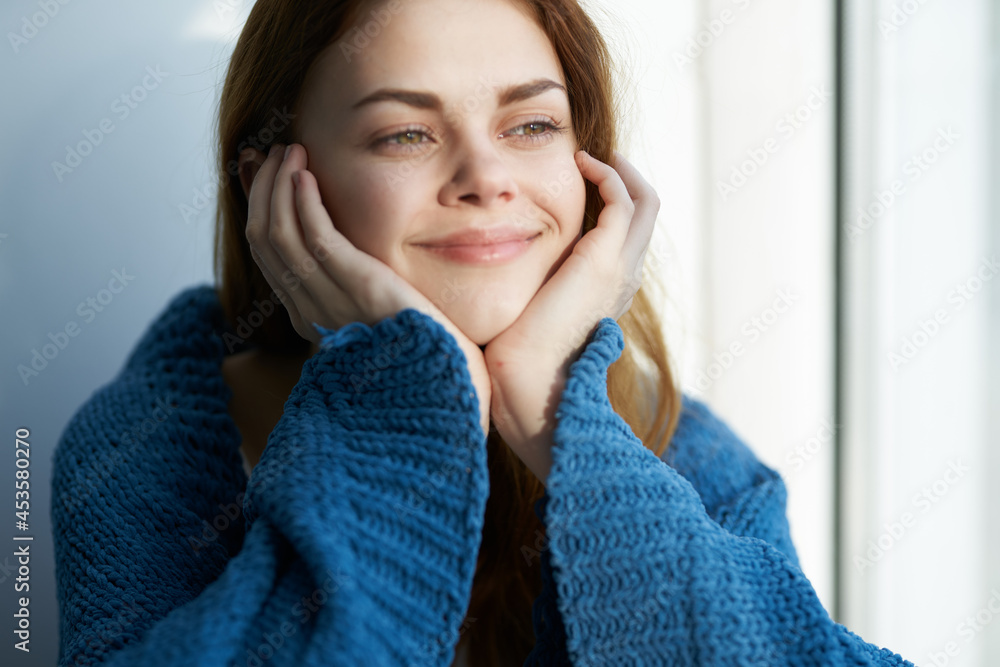 beautiful woman sitting near the window with a blue plaid beautiful woman sitting near the window with a blue plaid