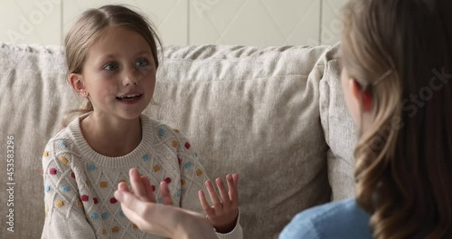 Close up little stuttered 9s cute girl studying pronunciation, repeat words correctly during lesson with teacher at home. Psychologist teach kid developing speech fluency. Vocal exercise class concept photo