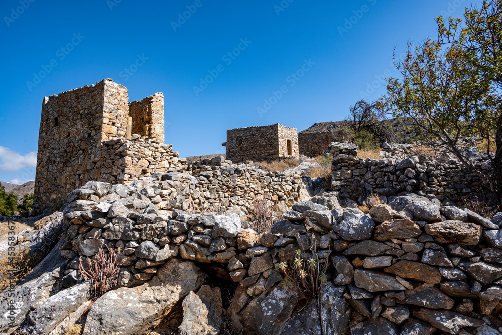 ancient stone mills and their ruins on the slopes of the mountains in Crete on a sunny day