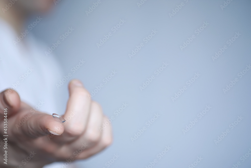 The concept of poor vision. Hold a contact lens and glasses in hand. A poster for advertising glasses and lenses. The concept of poor vision. Hold a contact lens and glasses in hand. A poster for advertising glasses and lenses.