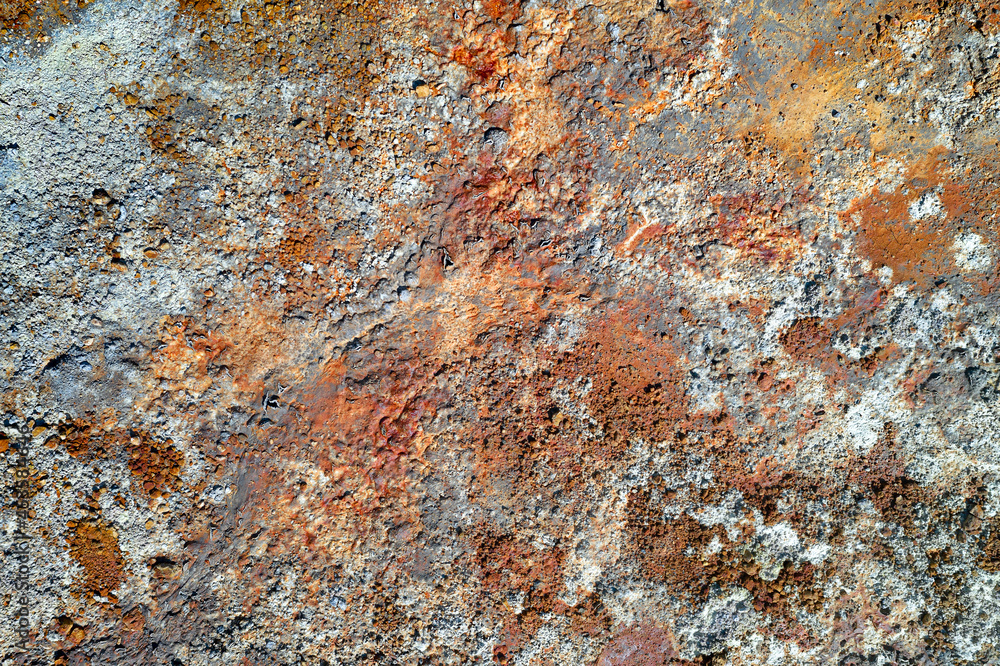 Rough stone surface with spots of rusty red and grey. Colorful texture in old mine Rough stone surface with spots of rusty red and grey. Colorful texture in old mine