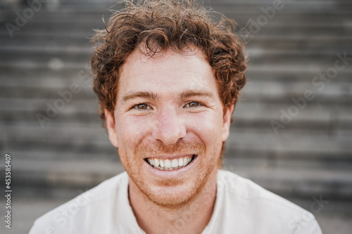 Photography Young man smiling on camera having fun outdoor in the city - Focus on face