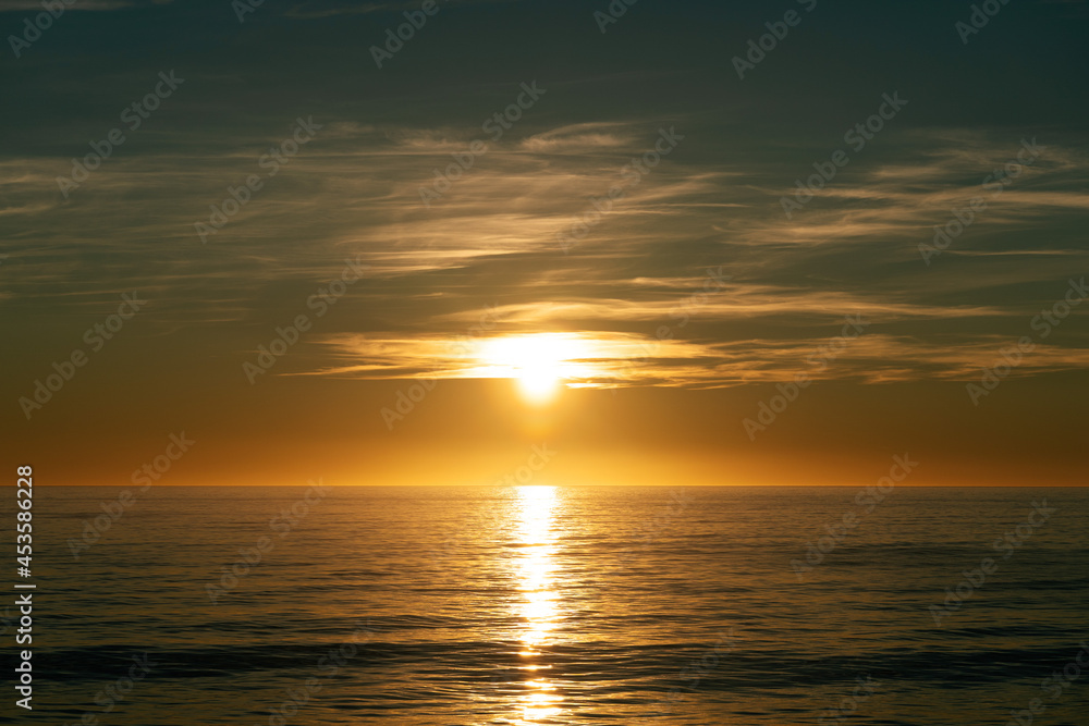 Beautiful sun rays by the ocean at sunrise