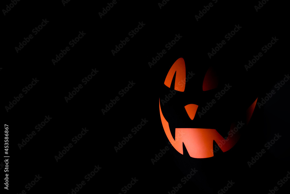 Halloween scary black air balloon with orange face on a black background.Minimalistic Halloween background.Copy space for text. Halloween scary black air balloon with orange face on a black background.Minimalistic Halloween background.Copy space for text.