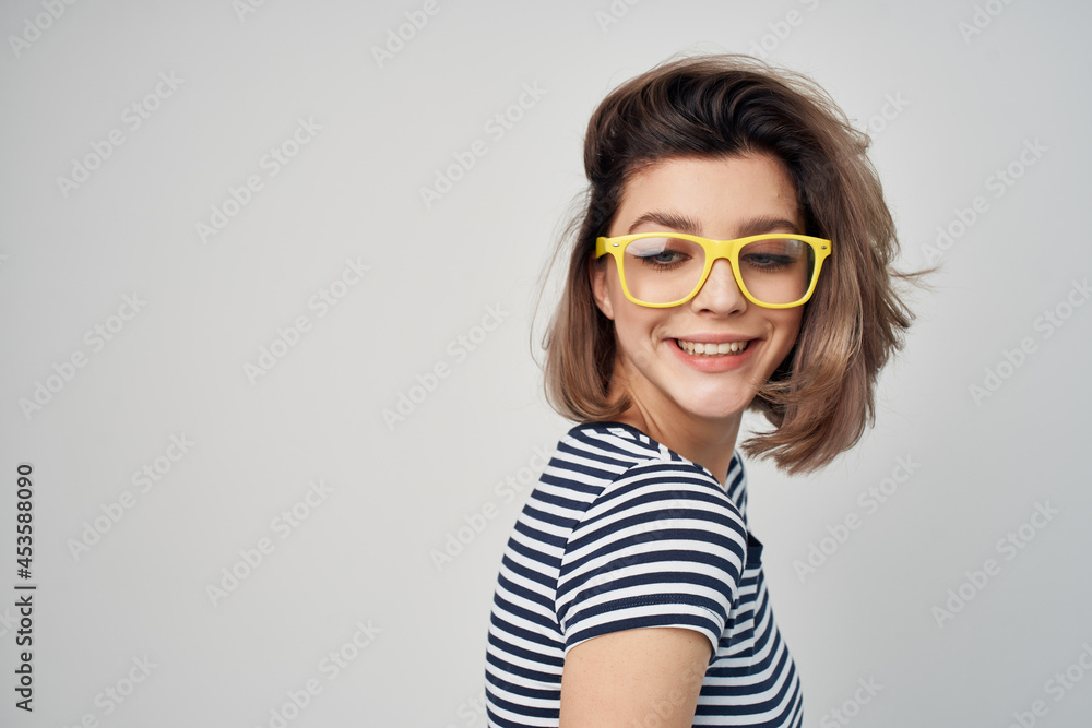 pretty woman in striped t-shirt glasses on gray background model pretty woman in striped t-shirt glasses on gray background model