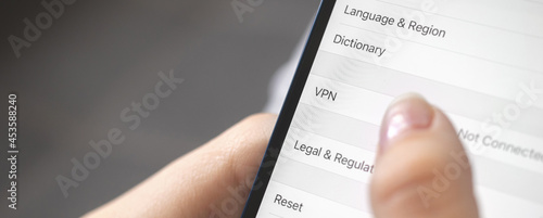 Person turn on the VPN setting on mobile phone, close-up, banner design photo