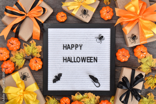 Flat lay happy halloween. Festive composition for Halloween on a wooden background with pumpkins and gifts.