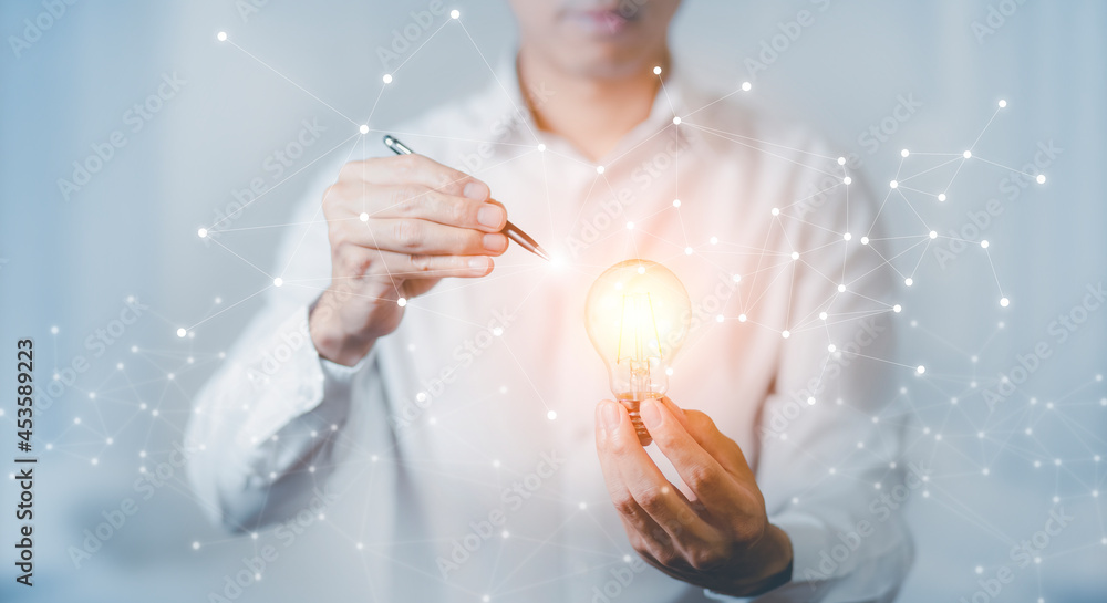 Businessman Catch the light bulb on blue background dark polygon digital network with using line flying globe social interaction concept.Creativity and innovation are keys to success.Concept Businessman Catch the light bulb on blue background dark polygon digital network with using line flying globe social interaction concept.Creativity and innovation are keys to success.Concept