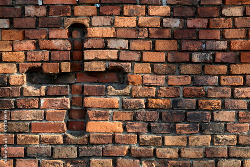 The sign of the cross carved into a brick wall