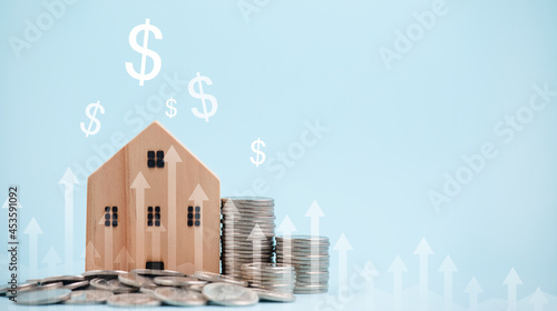 Coins stack in front of wooden home and arrow business, Save money concept, Property investment, house loan, reverse mortgage, gold coins money stack growth, saving money coins stack future for home