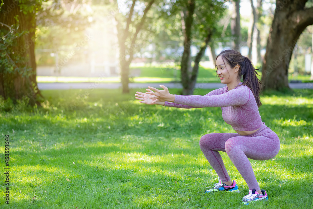 Young Asian woman doing yoga fitness exercises in the nature park, Exercise for health or warm-up body, fresh air, or Oxygen in the green tree in the park in sunlight. Young Asian woman doing yoga fitness exercises in the nature park, Exercise for health or warm-up body, fresh air, or Oxygen in the green tree in the park in sunlight.