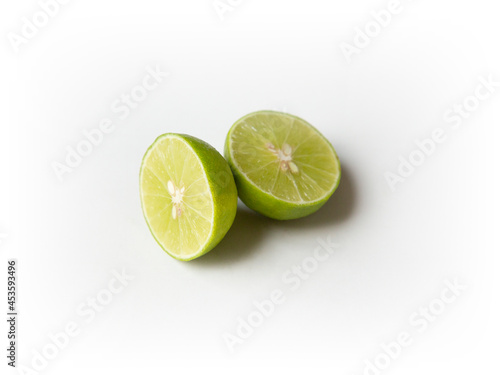 Ripe slice of green lime citrus fruit stand isolated on white background. Lime wedge with clipping path