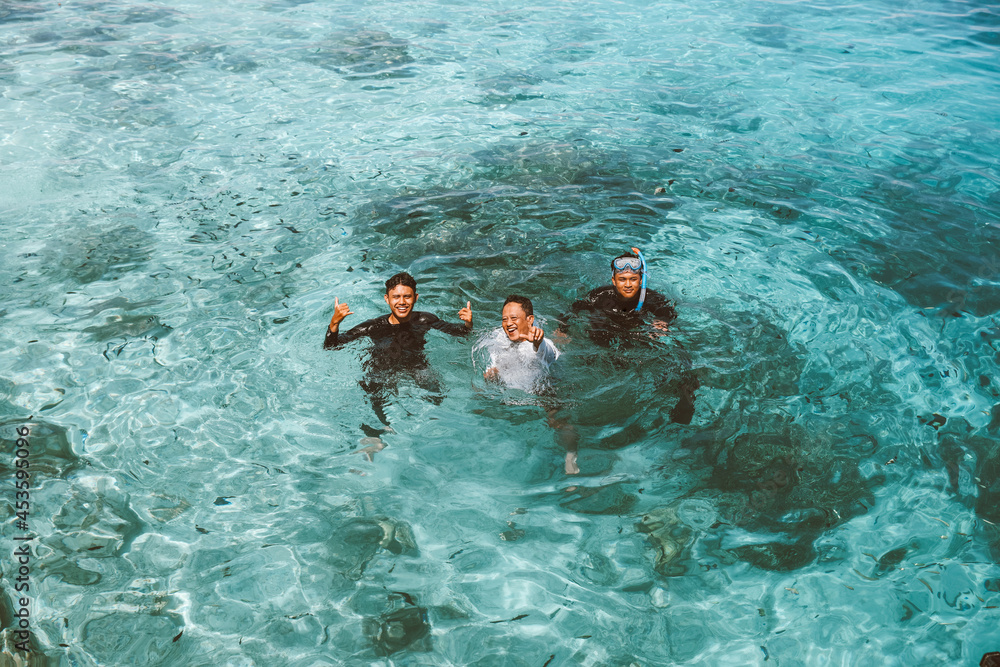 Happy man tourist take a picture together on the transparent sea water