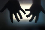 Hands reach out of the glass of the monitor, blurred background, horror concept