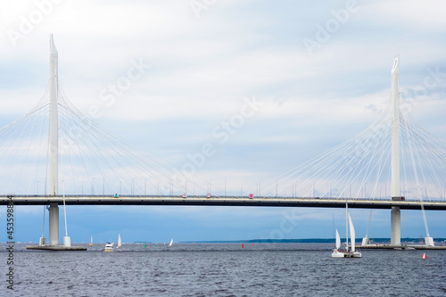 Western high-speed diameter in cloudy day, cable-stayed bridge over a Neva river and catamaran, sailboats and boats. Saint Petersburg, Russia