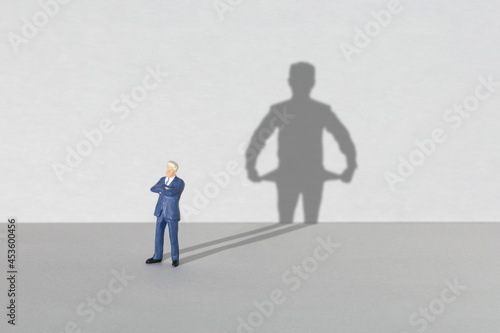 Poor businessman. Shadow of a businessman with empty pockets inside out. Crisis or bankruptcy concept