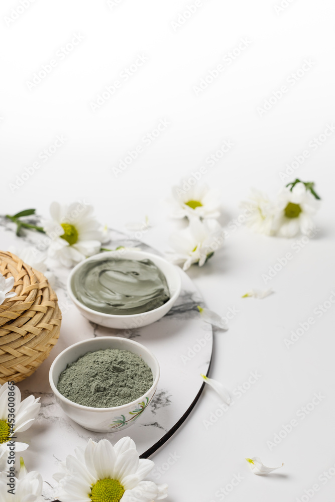 Two bowls with blue cosmetic clay powder and wet on marble on white background Two bowls with blue cosmetic clay powder and wet on marble on white background