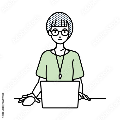 デスクで座ってPCを使っている教師の女性