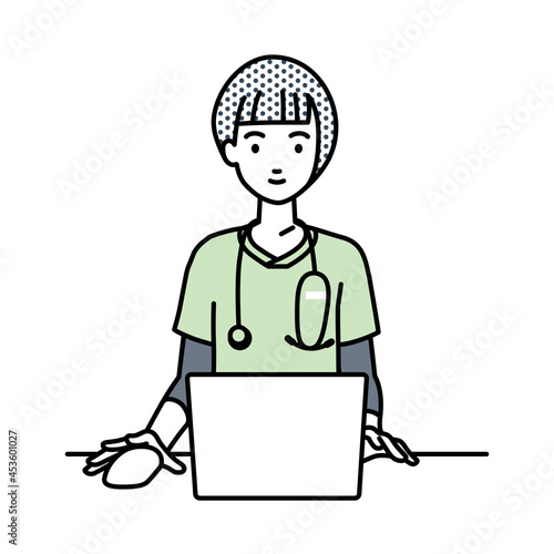 デスクで座ってPCを使っている看護師の女性