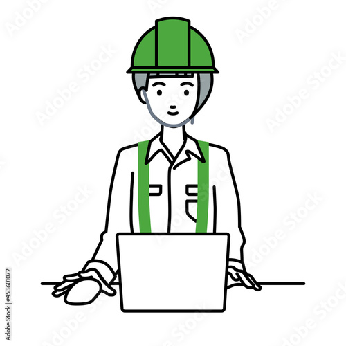 デスクで座ってPCを使っている工事現場の女性