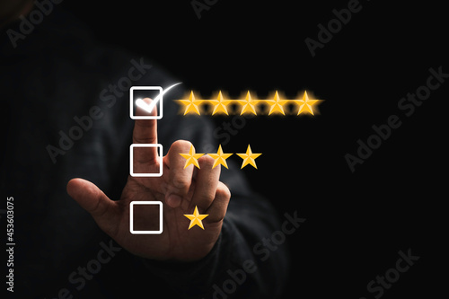 Businessman touching button to select five stars for the best excellent evaluation of customer satisfaction of product and service concept.