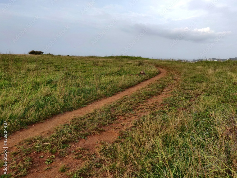 An old earthen road path running beyond the hills