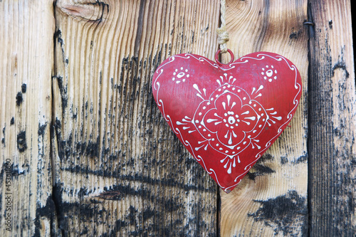 rotes bemaltes Herz vor Holzwand - painted deco heart on wooden board photo