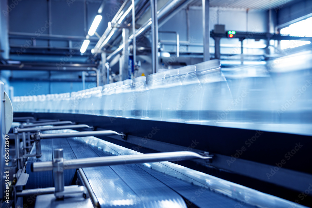 Obraz premium Conveyor belt with bottles of drinking water at a modern beverage plant.