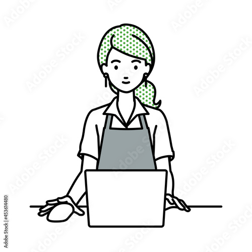 デスクで座ってPCを使っているカフェ店員の女性