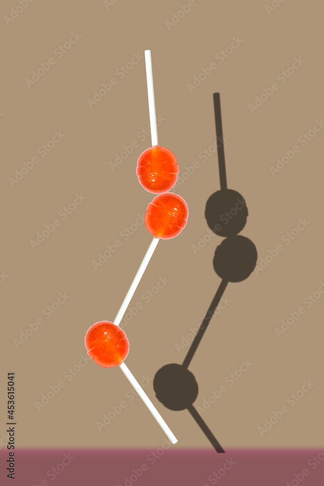 balancing lollipops candy on a stick against purple background balancing lollipops candy on a stick against purple background