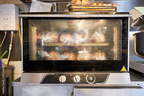 Industrial small size bread oven with cooked breads in a restaurant bakery kitchen