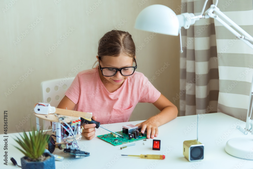 Girl is programming and building a scientific robotics project . STEM-education, distance learning, technology concept, hobby idea Girl is programming and building a scientific robotics project . STEM-education, distance learning, technology concept, hobby idea
