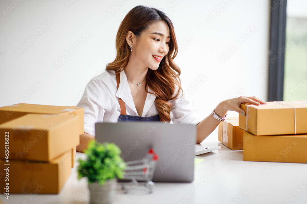 Portrait of Starting small businesses SME owners female entrepreneurs working on receipt box and check online orders to prepare to pack the boxes, sell to customers, sme business ideas online. Portrait of Starting small businesses SME owners female entrepreneurs working on receipt box and check online orders to prepare to pack the boxes, sell to customers, sme business ideas online.