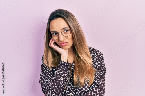 Beautiful hispanic woman wearing casual clothes and glasses thinking looking tired and bored with depression problems with crossed arms. © Krakenimages.com