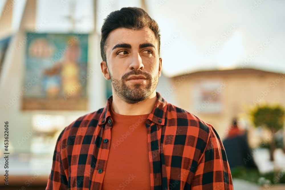 Young hispanic man with serious expression standing at the city. Young hispanic man with serious expression standing at the city.