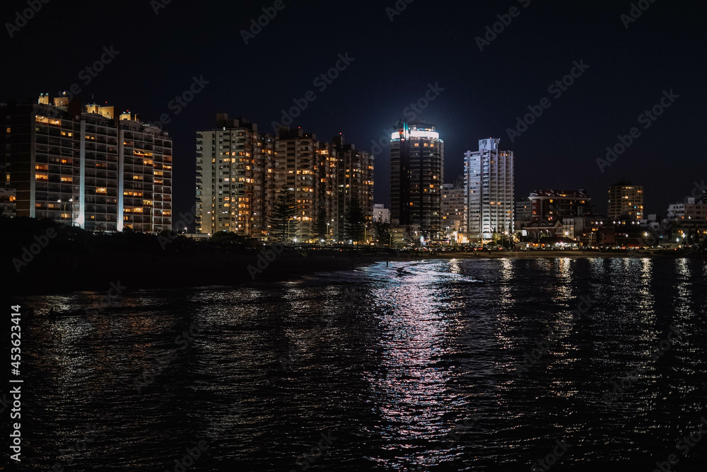 Imagen nocturna de unos edificios en una ciudad costera 