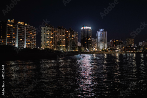 Imagen nocturna de unos edificios en una ciudad costera 
