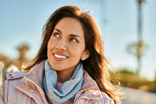 Young hispanic woman smiling happy standing at the city.