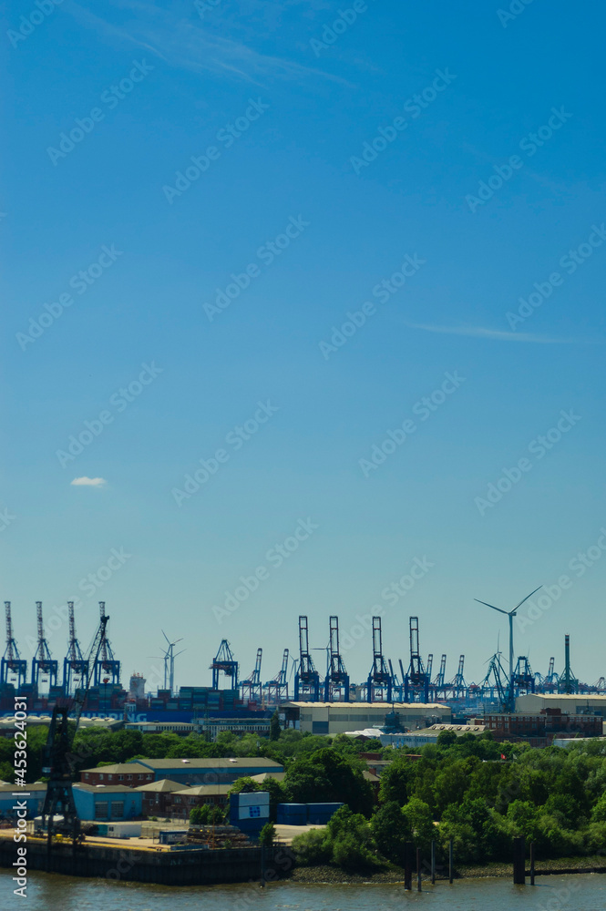 Naklejka premium View over the port of Hambrug with cargo ship, cranes and wind turbines | Hamburg, Germany